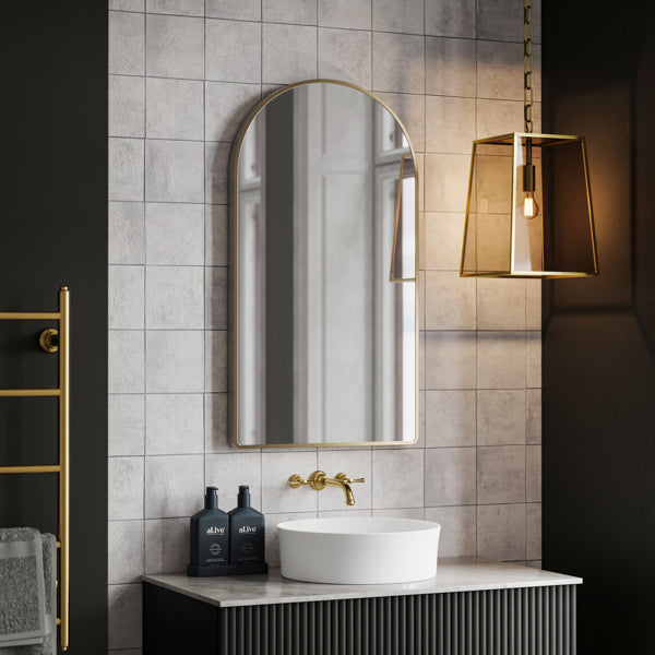 Ingrain arch wall mirror with brushed gold frame above a bathroom vanity, portrait view
