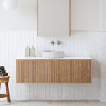 Ingrain grooved wall hung vanity in ash woodgrain with white top and round basin, shown in a modern bathroom