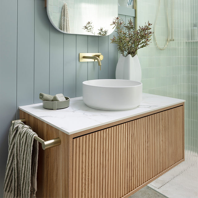 Ingrain Grooved wall hung vanity with fluted woodgrain front, white top and round basin in a modern bathroom setting