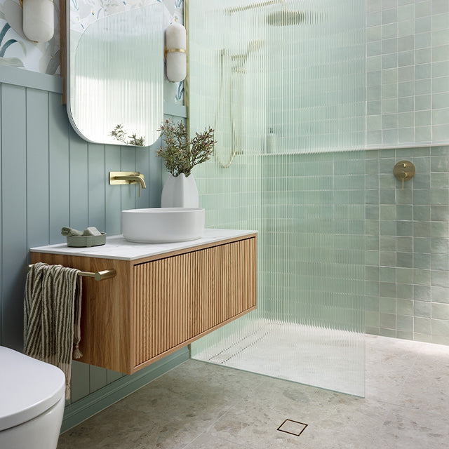 Ingrain Grooved wall-hung vanity in ash woodgrain with fluted drawer front, white top and round basin in bathroom setting