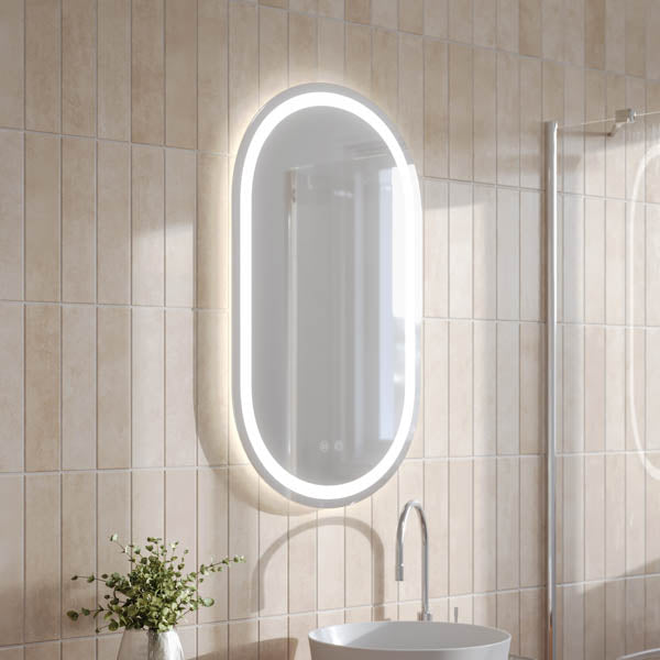 Ingrain pill frameless LED mirror with front and back light, wall hung in a bathroom setting, oval portrait view