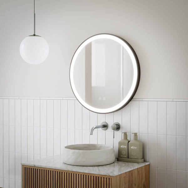 Ingrain round matte black framed frontlit LED mirror above bathroom vanity, wall hung with glowing edge in modern setting