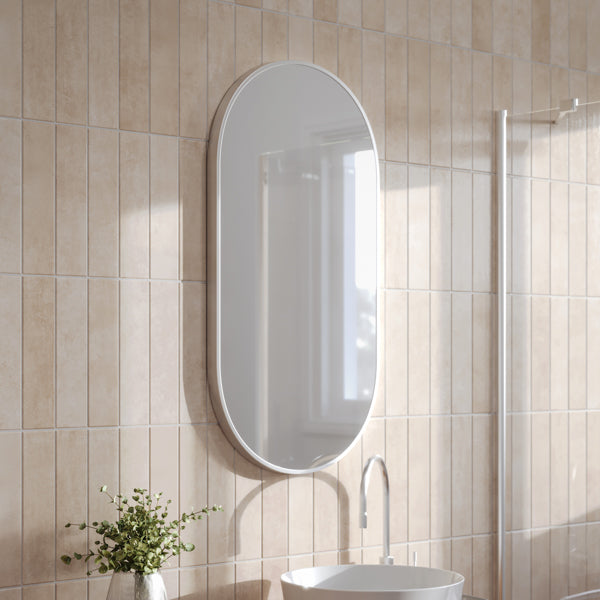 Ingrain pill-shaped brushed nickel framed wall mirror, portrait oval, on light grey wall