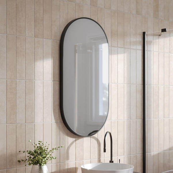 Ingrain pill-shaped matte black framed mirror above a bathroom vanity, wall hung in portrait view
