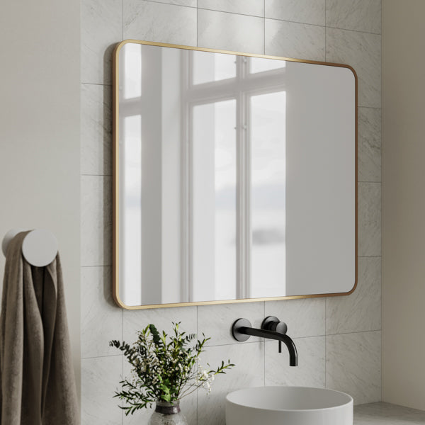 Ingrain rectangular mirror with brushed gold frame above a bathroom vanity, landscape wall-hung view