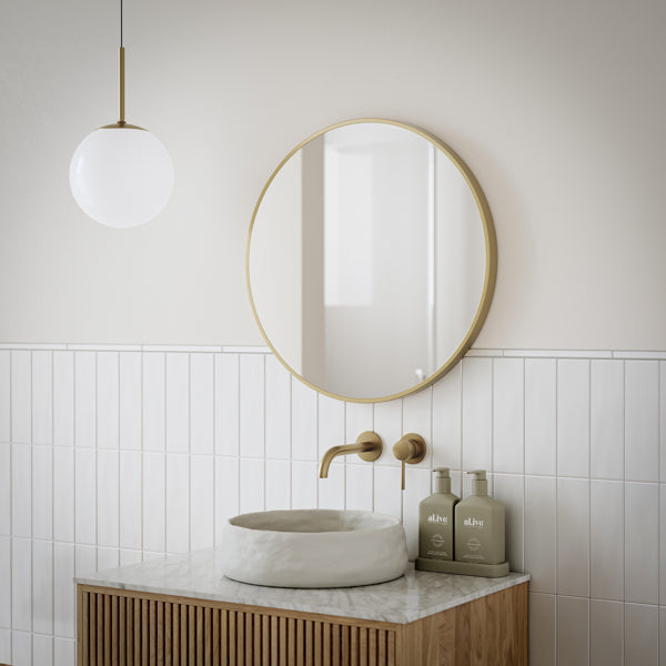Ingrain round brushed gold framed mirror, wall hung against a plain wall