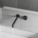 Nero Kara matte black wall-mounted progressive basin/bath set with 185mm curved spout and round handle on grey wall tiles
