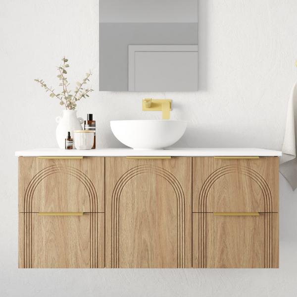 Marquis Arco wall hung vanity in prime oak with white benchtop, arched fronts, brass handles and round basin, front view
