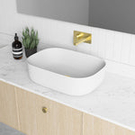 Marquis Chifley wall hung vanity with woodgrain finish, white benchtop and oval above-counter basin, shown in bathroom setting