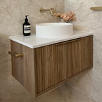 Marquis Cove wall hung vanity in oak woodgrain with white top and round basin, shown in a bathroom setting