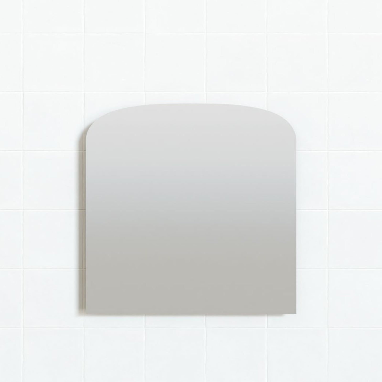 Marquis Pane frameless mirror with gently curved top, mounted on white tiled bathroom wall