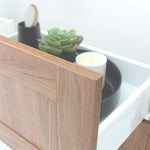 Marquis Pier wall hung vanity in natural oak woodgrain with white top, shown close-up with open drawer and tray accessories
