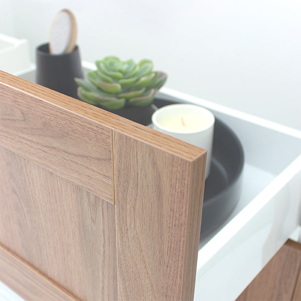 Marquis Pier wall hung vanity in natural oak woodgrain with white top, shown close-up with open drawer and tray accessories