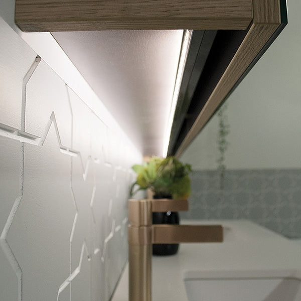 Close-up of ADP Moonlight shaving cabinet LED, showing concealed under-cabinet lighting and mirrored edge in natural oak finish