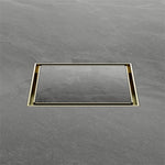 Nero square tile insert floor waste in brushed gold, shown flush in grey floor tiles