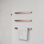 Nero Bianca single heated towel rail in brushed bronze, wall-mounted on tiled bathroom wall with towel draped over lower bar