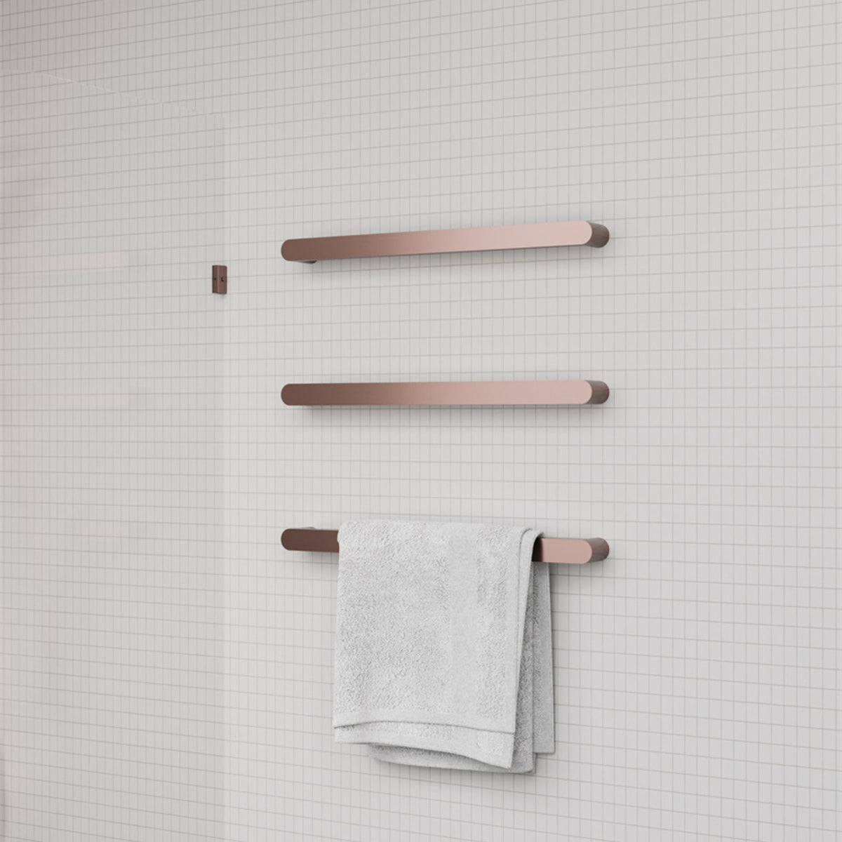 Nero Bianca single heated towel rail in brushed bronze, wall-mounted on tiled bathroom wall with towel draped over lower bar
