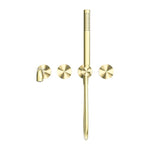 Nero Kara brushed gold wall-mounted shower system with separate plate, handheld shower and round spout on white background