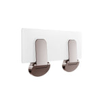 Nero Mecca Care fold-down shower seat in brushed bronze, shown folded flat against the wall