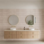 Wall-mounted Nero Mecca 3 piece basin/bath set in brushed gold above a twin vanity with round mirrors and basins