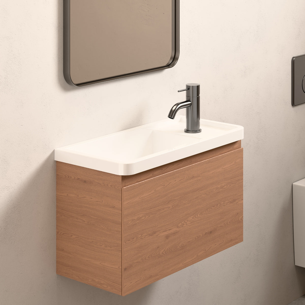 Nero Mecca mini basin mixer in gun metal, shown mounted on a compact bathroom vanity with white basin top