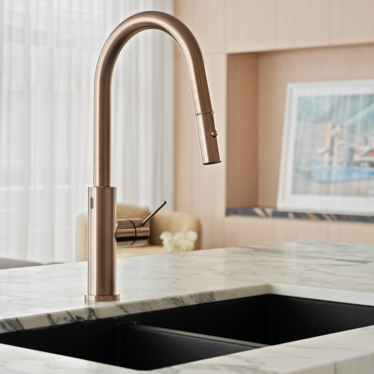Nero Mecca smart sensor pull out kitchen mixer in brushed bronze, shown installed on a marble benchtop over a black sink