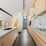 Nero Mecca Smart Sensor pull-out kitchen mixer in brushed bronze on a marble-look benchtop in a modern kitchen