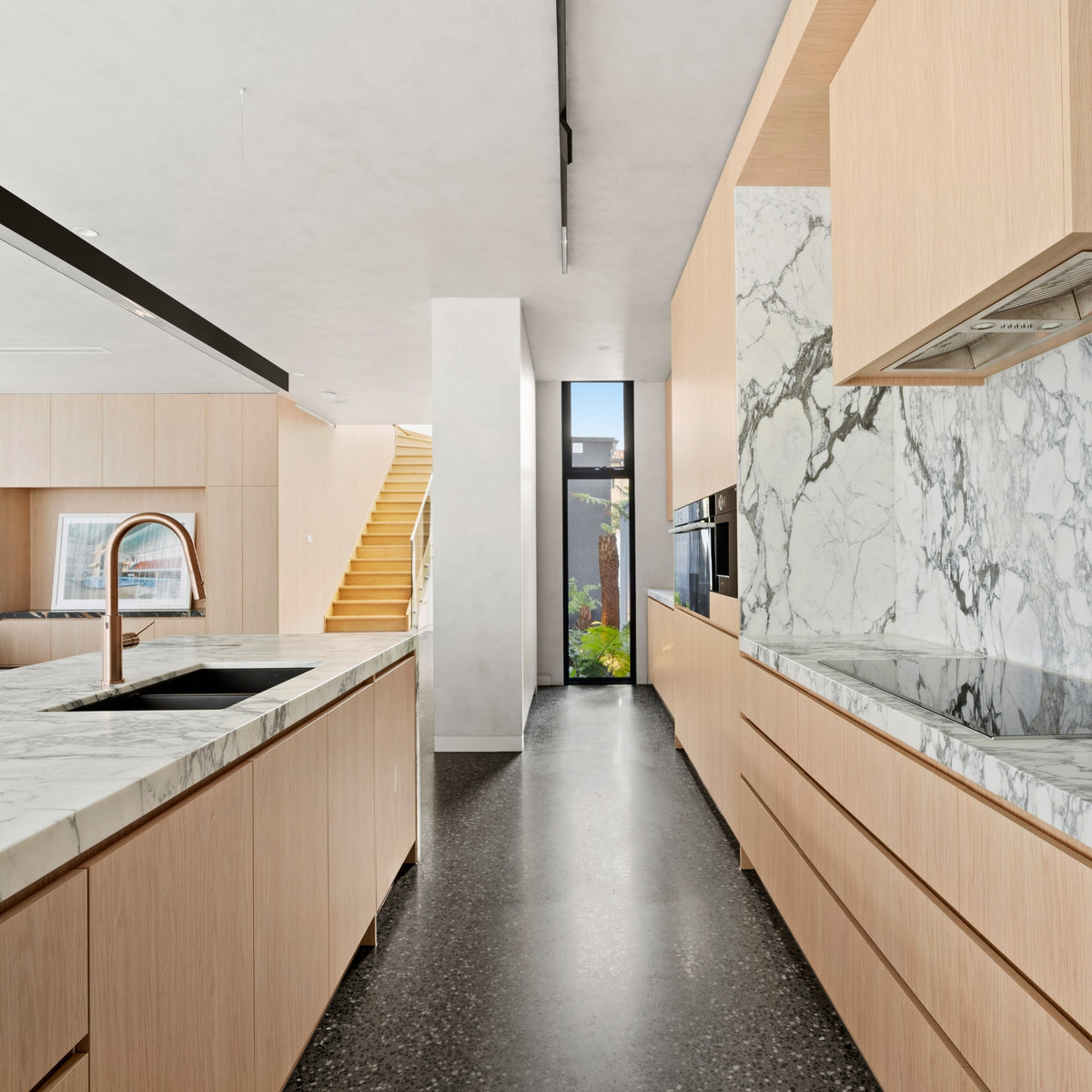 Nero Mecca Smart Sensor pull-out kitchen mixer in brushed bronze on a marble-look benchtop in a modern kitchen
