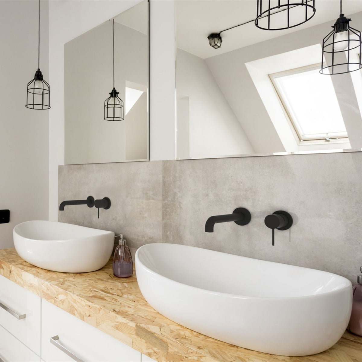 Matt black Nero wall basin/bath mixer set on a concrete-look bathroom wall with round back plates and spout