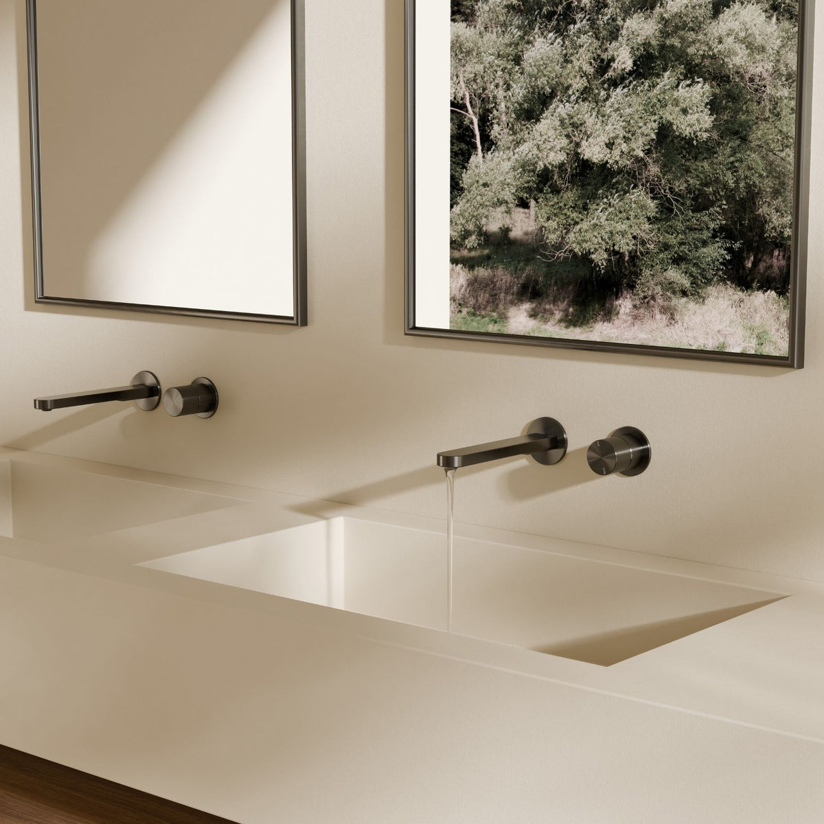 Nero Pure wall basin/bath mixer in graphite, wall-mounted over a bath with separate round back plates and slim spout