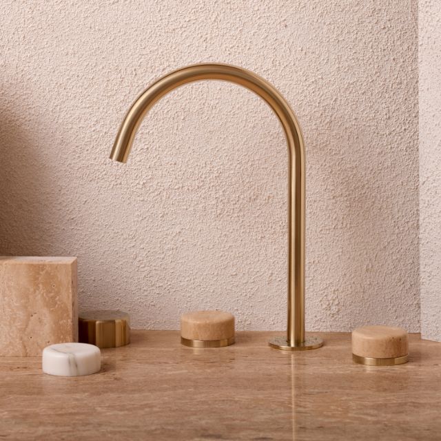 Nero Serenity brushed gold bath/kitchen set with arc spout and mixed stone handles on a travertine benchtop