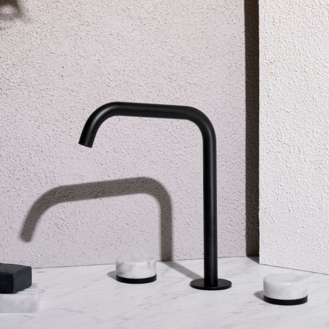 Nero Serenity matte black wall-mounted edge spout tap with square profile, shown on a marble benchtop with marble handle accents