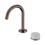 Nero Serenity basin mixer in brushed bronze with arc spout and round Carrara marble handle, isolated on white