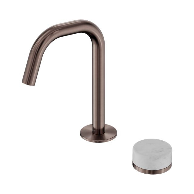 Nero Serenity basin mixer in brushed bronze with edge spout and white Carrara marble handle, isolated on white