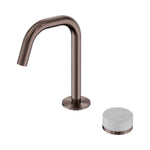 Nero Serenity basin mixer in brushed bronze with edge spout and white Carrara marble handle, isolated on white