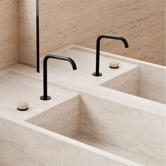 Nero Serenity matte black gooseneck sink mixers with curved spouts and travertine handles over a double stone basin