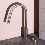 Nero Serenity pull-out kitchen mixer in brushed nickel, shown in side view with curved gooseneck spout and separate metal handle on benchtop