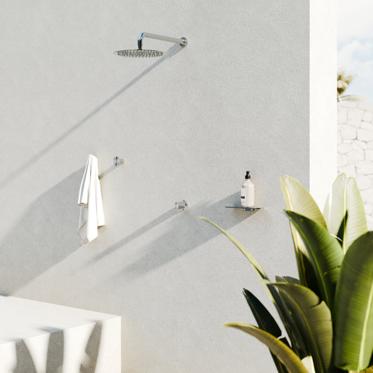 Nero Pure brushed nickel shower mixer set on wall with round shower rose in a modern outdoor bathroom scene