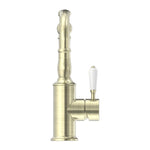 Nero York aged brass basin mixer tap with hook spout and white porcelain lever, side view on white background