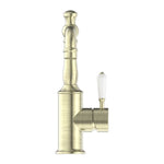 Nero York basin mixer tap in aged brass with white porcelain lever, side view, on white background