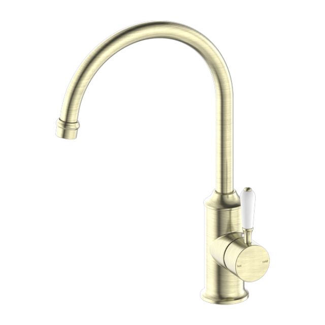 Nero York kitchen mixer tap in aged brass with gooseneck spout and white porcelain lever, isolated on white