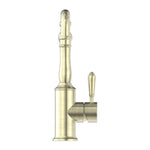 Nero York kitchen mixer with hook spout and metal lever in aged brass, side view on white background