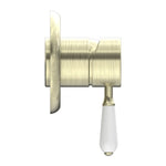 Nero York shower mixer in aged brass with white porcelain lever, side view, wall-mounted bathroom tap