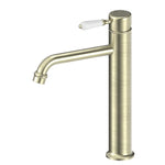 Nero York tall basin mixer tap in aged brass with white porcelain lever, straight cylindrical body and curved spout