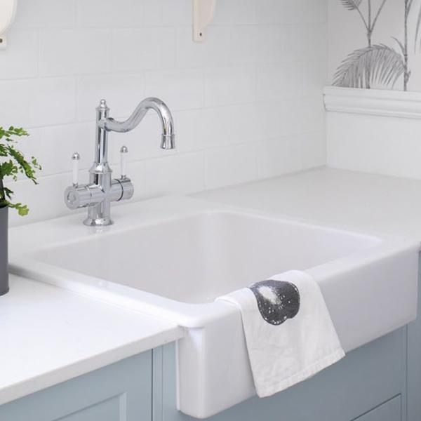 Phoenix Nostalgia twin handle sink mixer in chrome and white, with shepherds crook spout on a white farmhouse sink