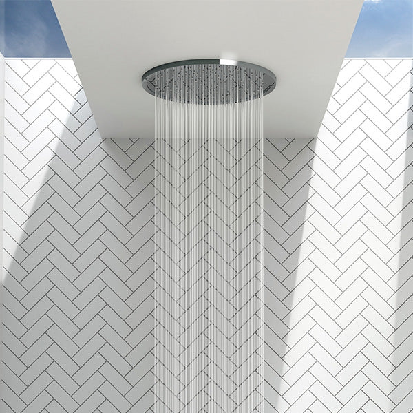 Phoenix Vivid Slimline round chrome ceiling shower head, flush mounted in ceiling, with water spraying over tiled shower wall.