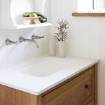 Phoenix Cromford brushed nickel wall basin/bath tap set with spout, shown installed over a vanity sink