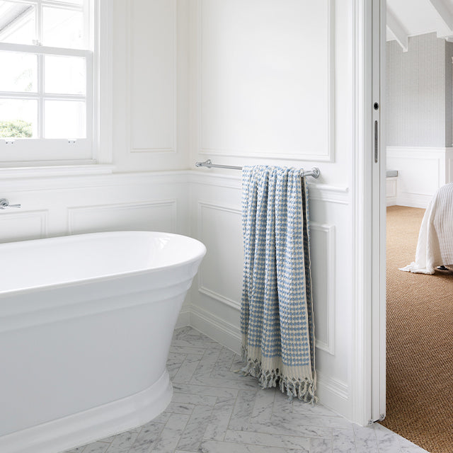 Phoenix Cromford chrome single towel rail mounted on a white bathroom wall with a blue towel draped over it