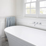Phoenix Cromford chrome wall top tap assemblies on a white bath wall, shown in a classic bathroom setting