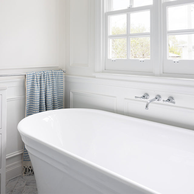 Phoenix Cromford chrome wall top tap assemblies on a white bath wall, shown in a classic bathroom setting